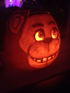 a pumpkin with an animal face carved into it's head and glowing eyes in the dark