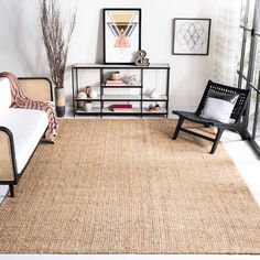 a living room with a couch, chair and rug on the floor in front of a window