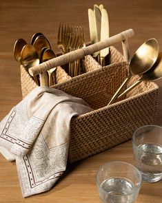 silverware and utensils in a woven basket with napkins on a wooden table