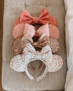 a group of minnie mouse ears sitting on top of a chair next to a pillow