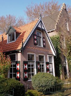 a house with red and white quilts on the windows