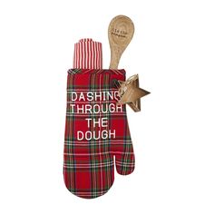 a red plaid oven mitt with a wooden spoon in it that says dashing through the dough