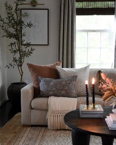 a living room with a couch, coffee table and two candles on top of it