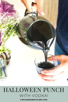 someone pouring black liquid into a glass with purple flowers in the background and text overlay that reads halloween punch with vodka