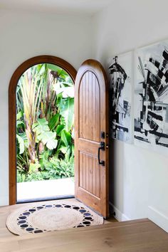 an open wooden door leading to a tropical garden