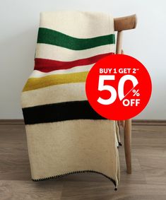 a chair that has a blanket on it with the sale 50 % off sign next to it