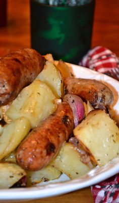 a white plate topped with sausage and potatoes