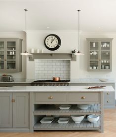 a kitchen with grey cabinets and white counter tops