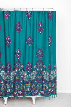 a blue shower curtain with purple and green designs