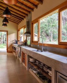 a kitchen with lots of counter space and wooden beams on the ceiling, along with large windows