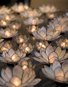 many lit candles are placed in the shape of lotuses