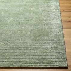 a light green rug on a wooden floor