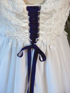 the back of a wedding dress with blue ribbon