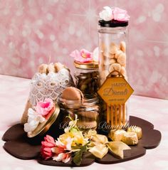 a table topped with jars filled with cookies and flowers