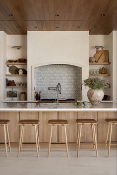 a kitchen with an oven, counter and stools