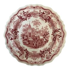 a red and white plate with an image of a town on it