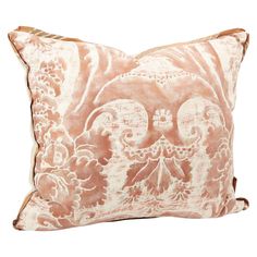 a pink and white pillow with an intricate design on the front, sitting against a white background