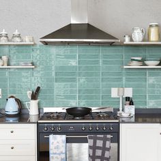 a stove top oven sitting inside of a kitchen next to a microwave and toaster