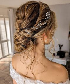 a woman in a wedding dress wearing a hair comb with pearls on it's head