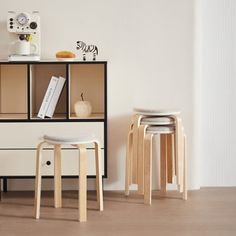 two stools sit in front of a book shelf