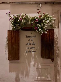 an old building with flowers on the window sill and sign above it that says, innamonea del te dell vita