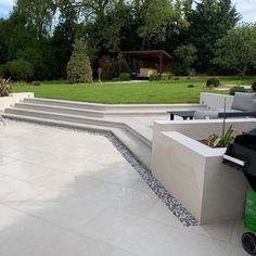 an outdoor patio with steps leading up to the back yard and seating area in front of it