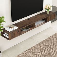 a flat screen tv mounted to the side of a wooden entertainment center next to a potted plant