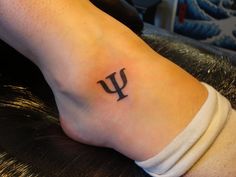 a person with a tattoo on their foot that has the letter u in black ink