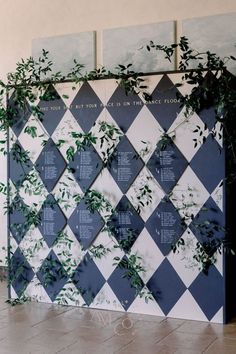 the wall is decorated with blue and white checkered tiles, greenery on each side