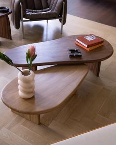 a wooden table with a vase on it and a book sitting on top of it