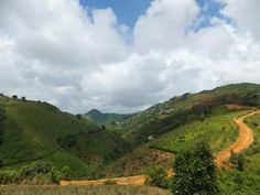 a dirt road in the middle of green hills