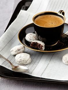 a cup of coffee and some cookies on a table