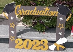 a graduation sign on the side of a sidewalk