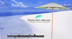 an umbrella sitting on top of a sandy beach next to the ocean and blue sky