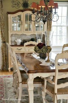 a dining room table with chairs and a chandelier in the middle of it