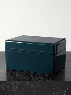 a blue box sitting on top of a black marble counter next to a white wall