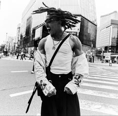 a man with dreadlocks walking across a street