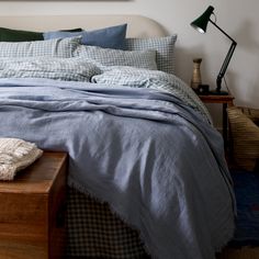 a bed with blue sheets and pillows in a bedroom