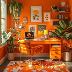 an orange home office with lots of plants and pictures on the wall above the desk