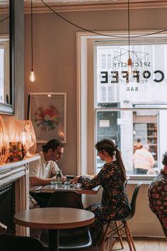 people sitting at tables in a coffee shop