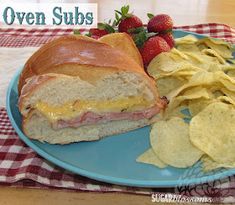 a sandwich and chips on a blue plate with the words oven subs over it