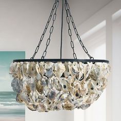 a chandelier made out of seashells hangs from a ceiling in a room