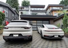 two white porsches parked in front of a house