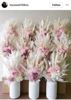 three white vases filled with pink and white flowers