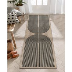 an area rug with two circles on it in front of a chair and potted plant