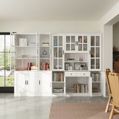 a dining room table and chairs in front of a bookshelf