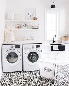 a washer and dryer in a white laundry room with black and white flooring