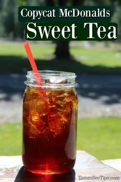 a jar filled with iced tea sitting on top of a wooden table