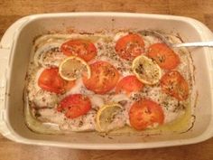 a casserole dish with tomatoes and lemons