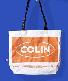 an orange and white bag with the word coln on it hanging from a hook